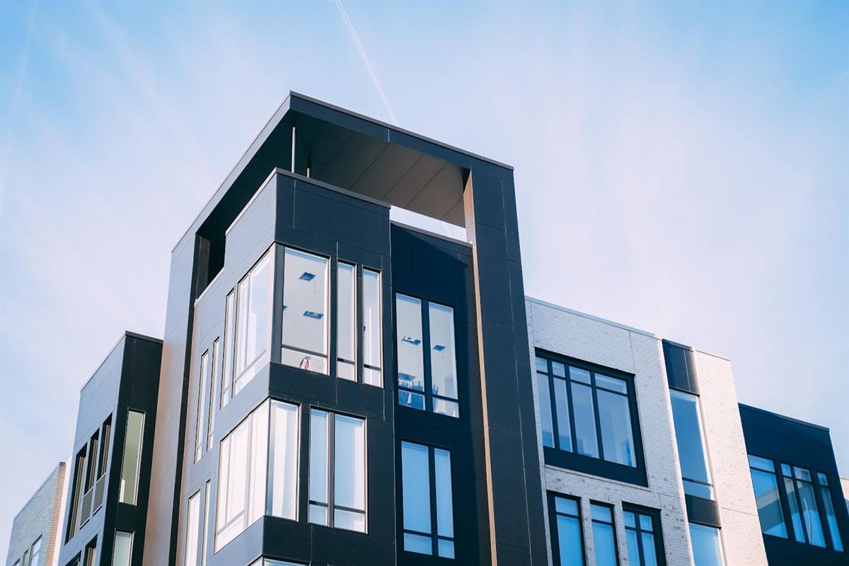 A modern low-rise residential building against a clear sky